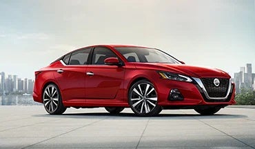 2023 Nissan Altima in red with city in background illustrating last year's 2022 model in Mentor Nissan in Mentor OH